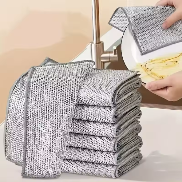 Stack of metallic scrubbing pads with a kitchen setting in the background